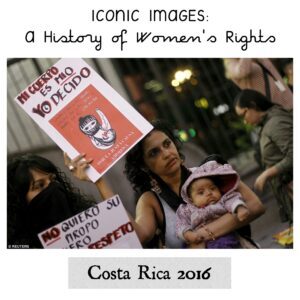 The image shows a woman holding her baby and a sign that reads - "My body is mine, I decide".