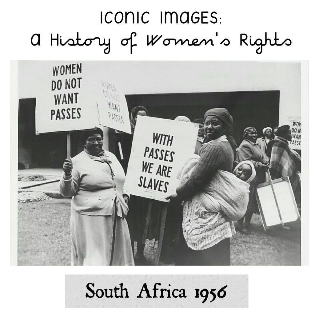 The image shows women demonstrating against passes. They are holding signs that say - "we do not want passes" and "with passes, we are slaves"